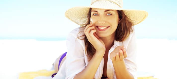 woman laying on the beach, summer eye care, sunlight eye protection, outdoor eye protection, eye exam Springfield MA