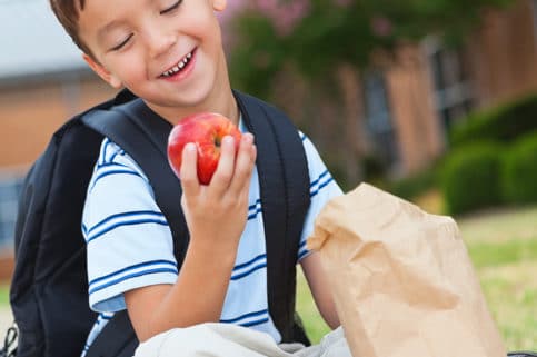 Little boy with backpack on holding an apple, snacks for eye health, eye care Springfield MA, eye doctor Western MA, Dr. John Papale